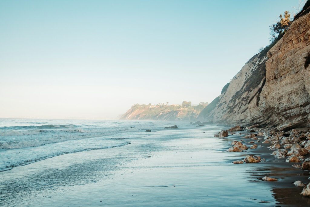 brown rocky mountain beside body of water during daytime in Santa Barbara