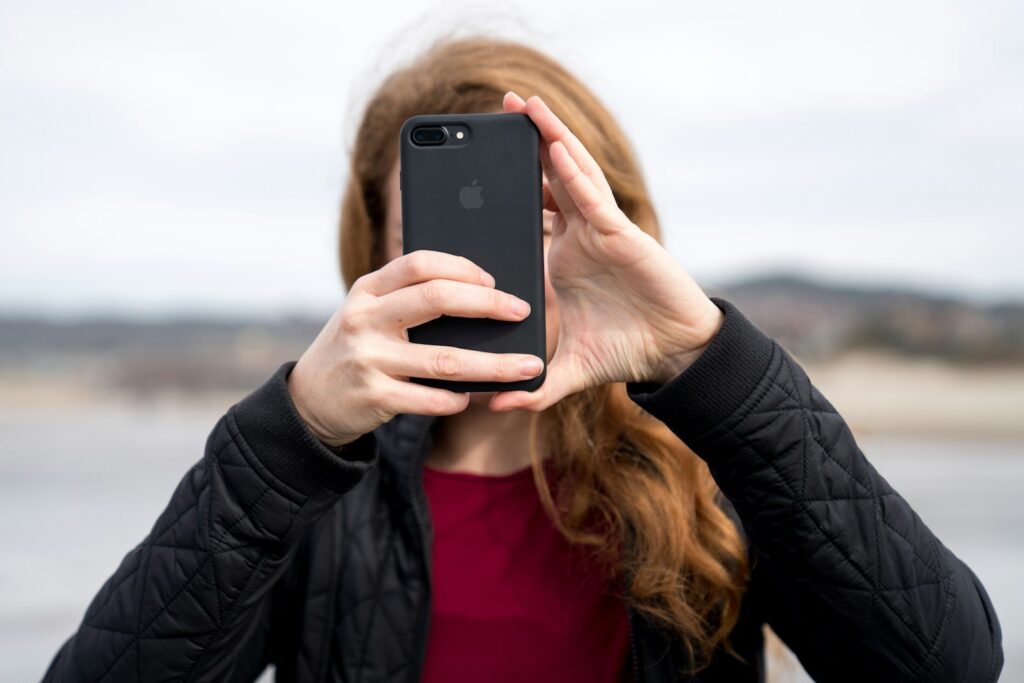 woman taking photo using black iPhone