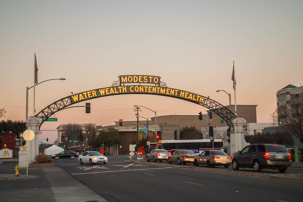 An archway above a road that says Modesto, CA: Water Wealth Contentment Health