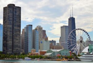 Chicago cityscape showcasing the river, Navy Pier, Willis Tower, and other skyscrapers against a blue sky