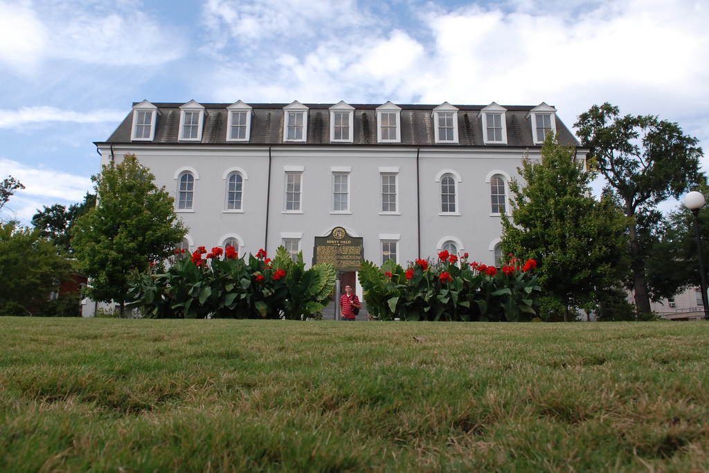 White three story university building surrounded by greenery