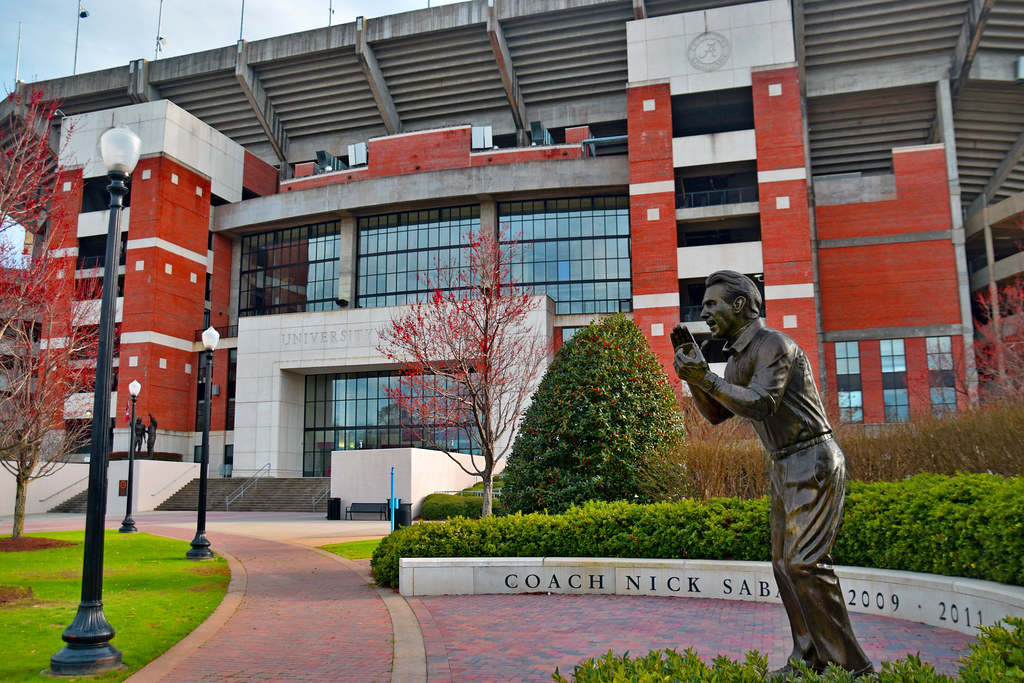 Bronze statue outside a red brick football stadium