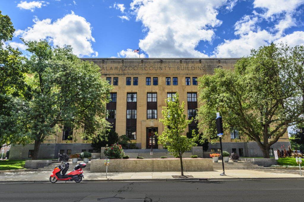 brick courthouse building with green trees against a blue sky