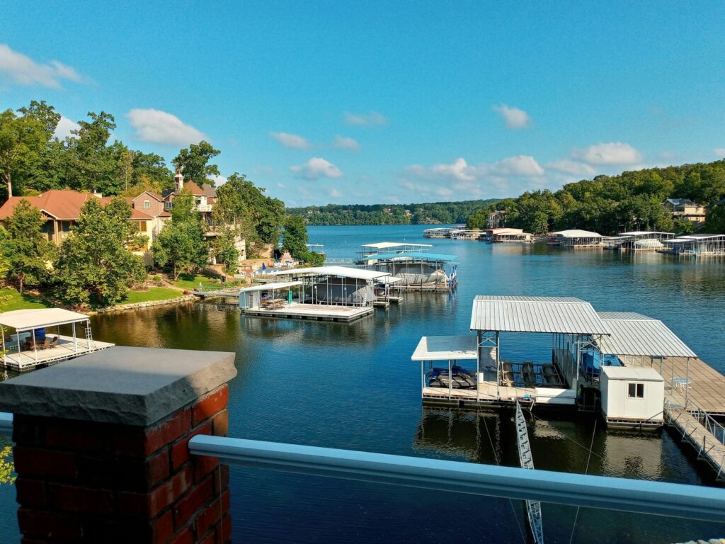 Lake of the Ozarks in Missouri with boats and docks in the water against a blue sky and surrounded by homes on the shore