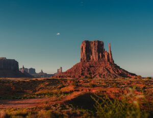 brown rock formation against a blue sky in Monument Valley, Arizona